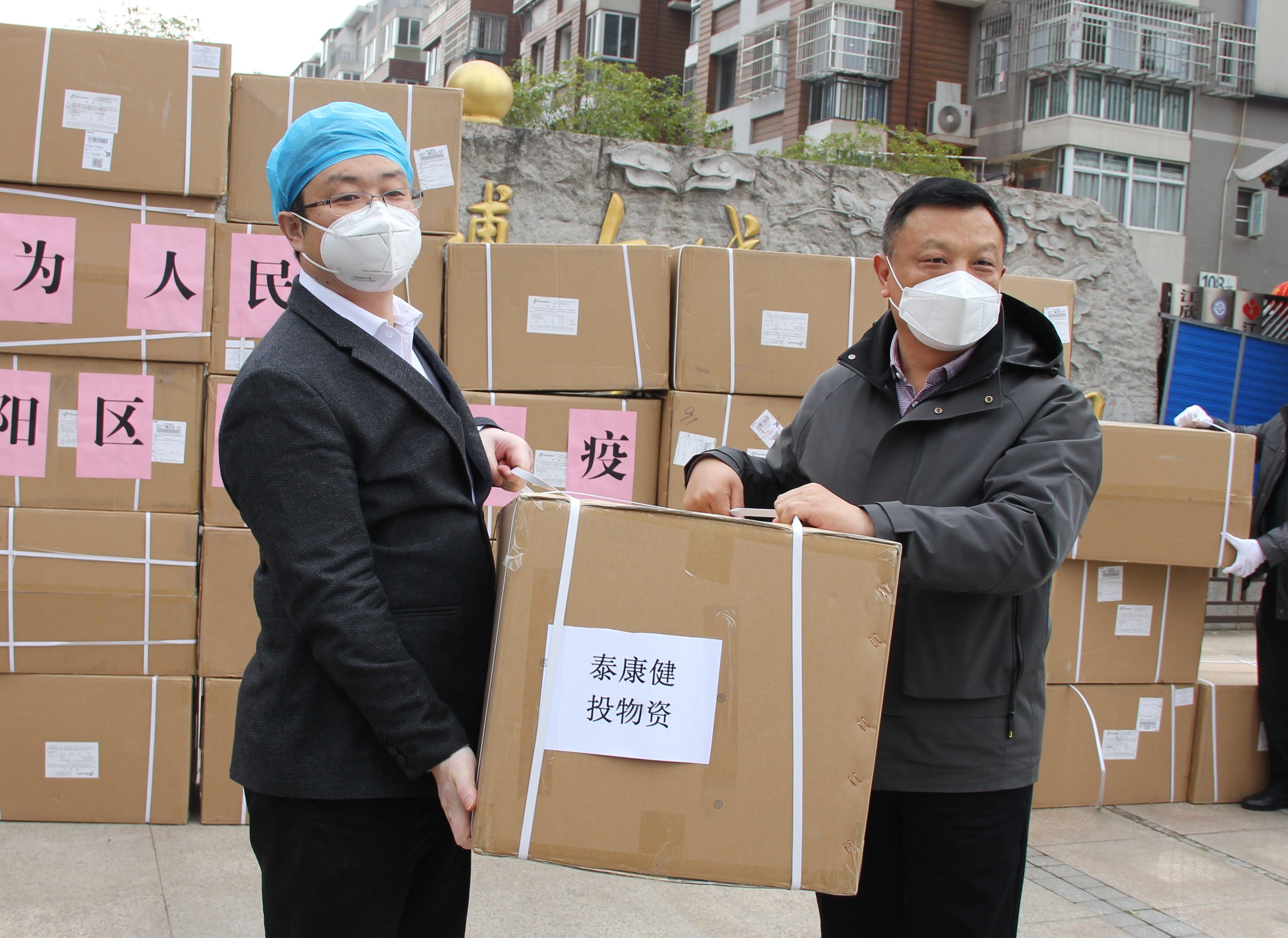 泰康同濟（武漢）醫(yī)院 執(zhí)行院長肖駿（左）向漢陽區(qū)人大常委會副主任葉平（右）捐贈抗疫情物資